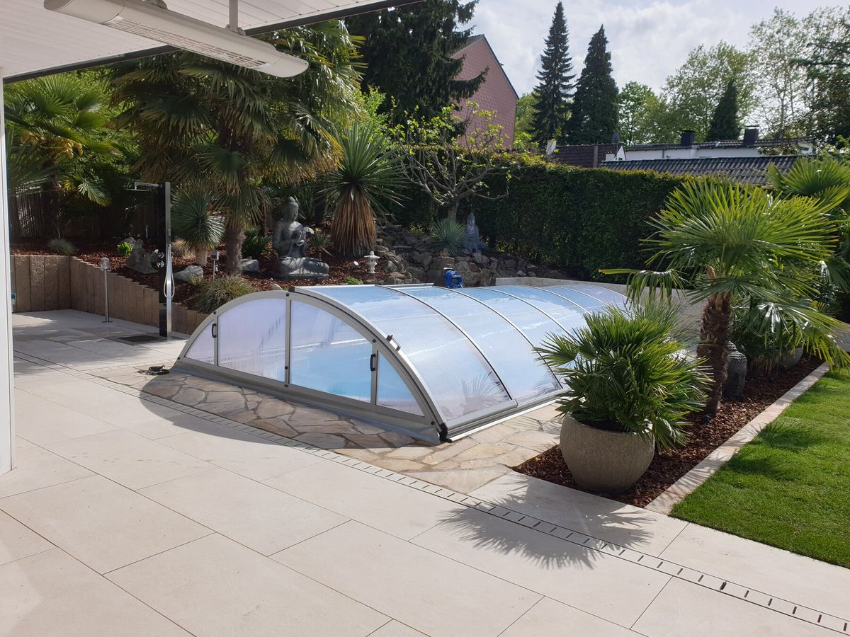 Pool mit Naturstein-Trockenmauer, Buddha-Statue und Palmen