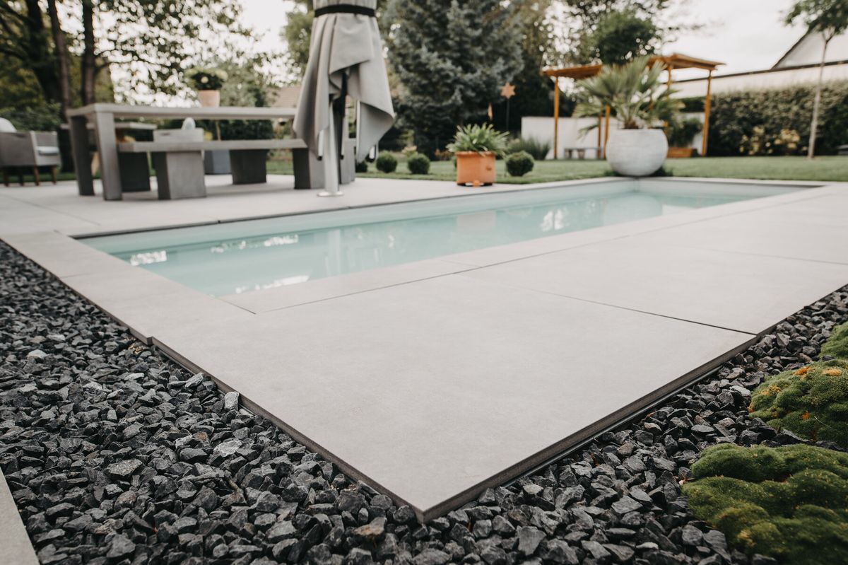 Terrasse mit Lounge- und Essbereich rund um den Pool